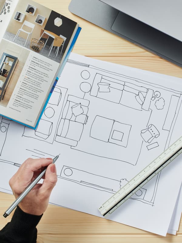 Ritningar, antrecknisgsblock och en katalog på ett träbord, 