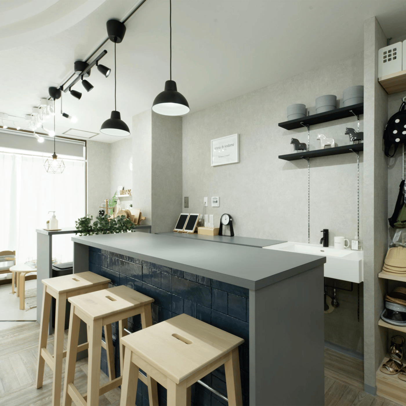 作りつけのグレーのカウンターテーブルに無垢材のハイチェアを組み合わせた空間