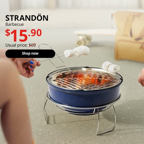 Roasting of marshmallows over the charcoal blue STRANDÖN barbecue. Black text over image that reads "STRANDÖN, Barbecue. Price at $15.90, Usual price $69"
