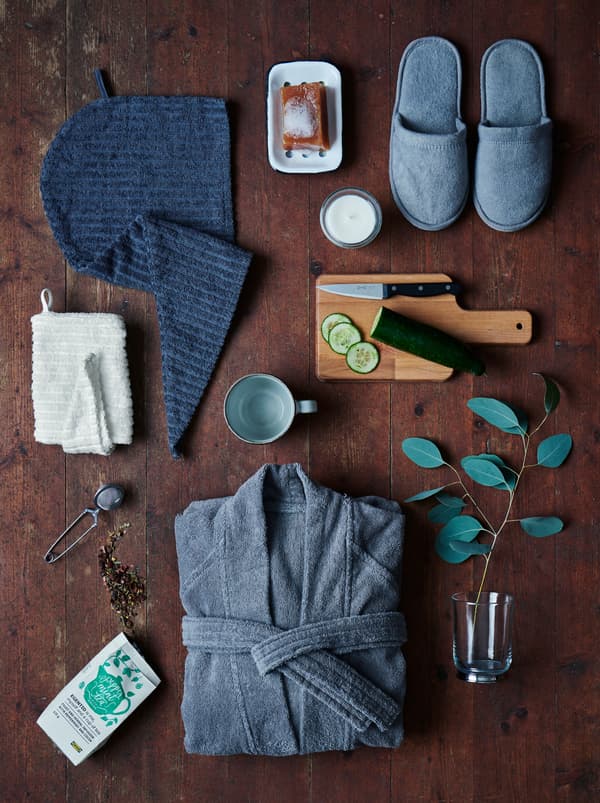 ของใช้สำหรับวันที่ทำสปาที่บ้านอย่าง ROCKÅN/ร็อคคอน และชา EGENTID/เอียเยนติด จัดเรียงอยู่บนพื้นไม้สีเข้ม