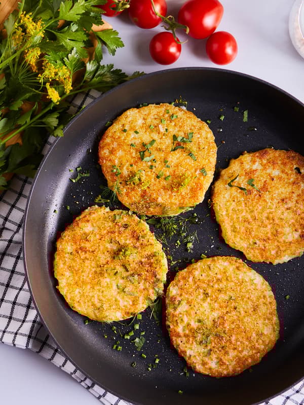 RÖSTI krumplipogácsákat látunk egy fekete serpenyőben.