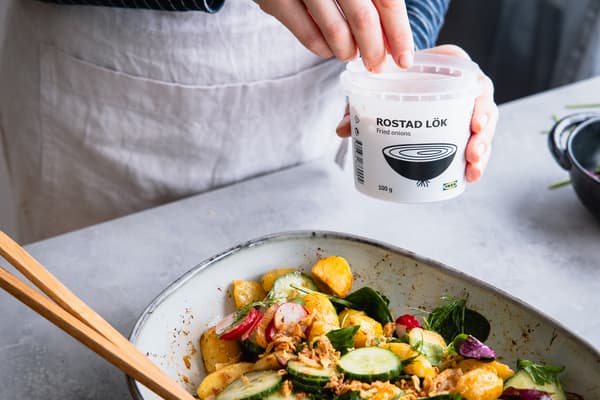 Röstzwiebeln werden auf den Kartoffelsalat gestreut.