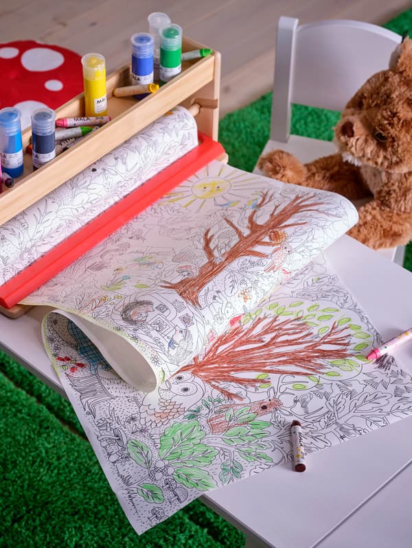 Rolka papiera s maľovankami SKOGSDUVA je v stojane MÅLA s farbami MÅLA.