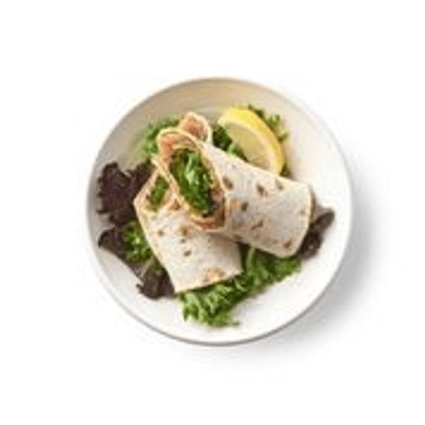 Rollito de salmón marinado, servido en un pan plano integral con verduras variadas