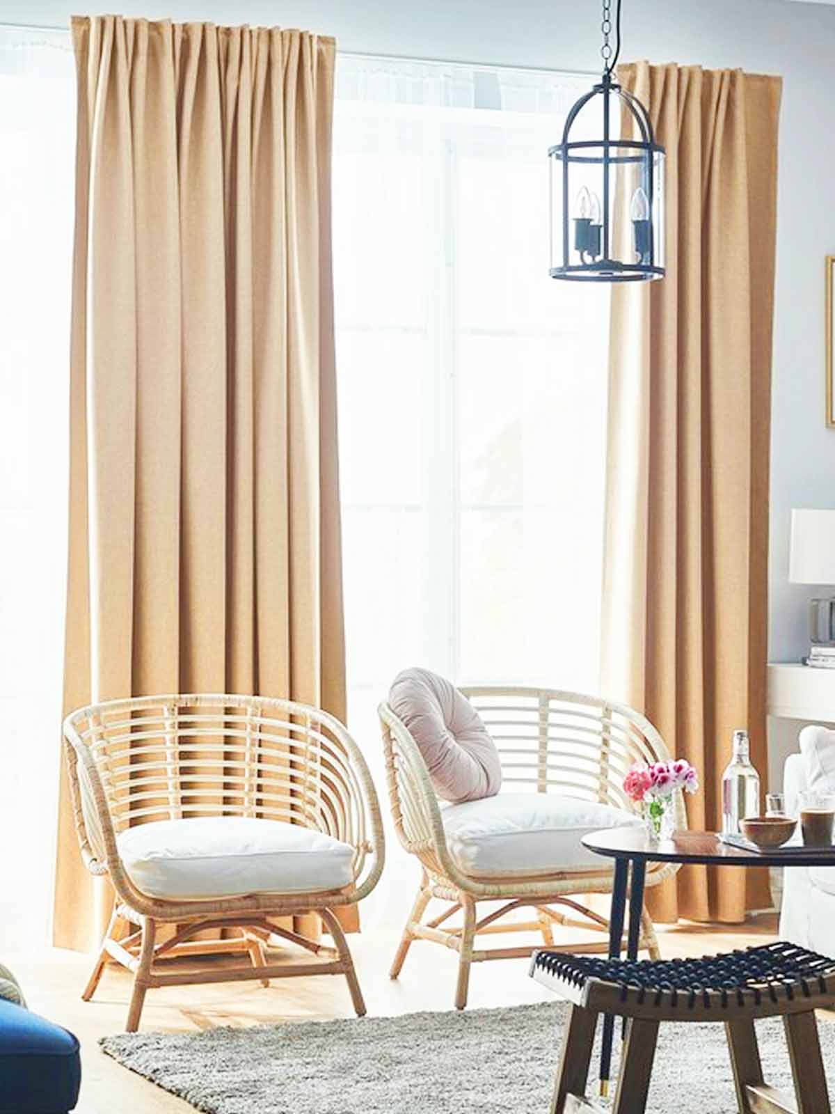 Room darkening beige ANNAKAJSA curtains hung over full length windows in the living room