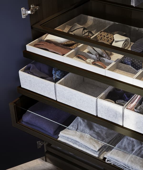 Ropa y accesorios guardados en cajones, bandejas, compartimentos de cajón y estantes.