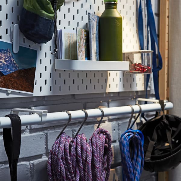 Ropes and climbing gear hanging from hooks placed on a white IKEA HUGAD curtain rod.
