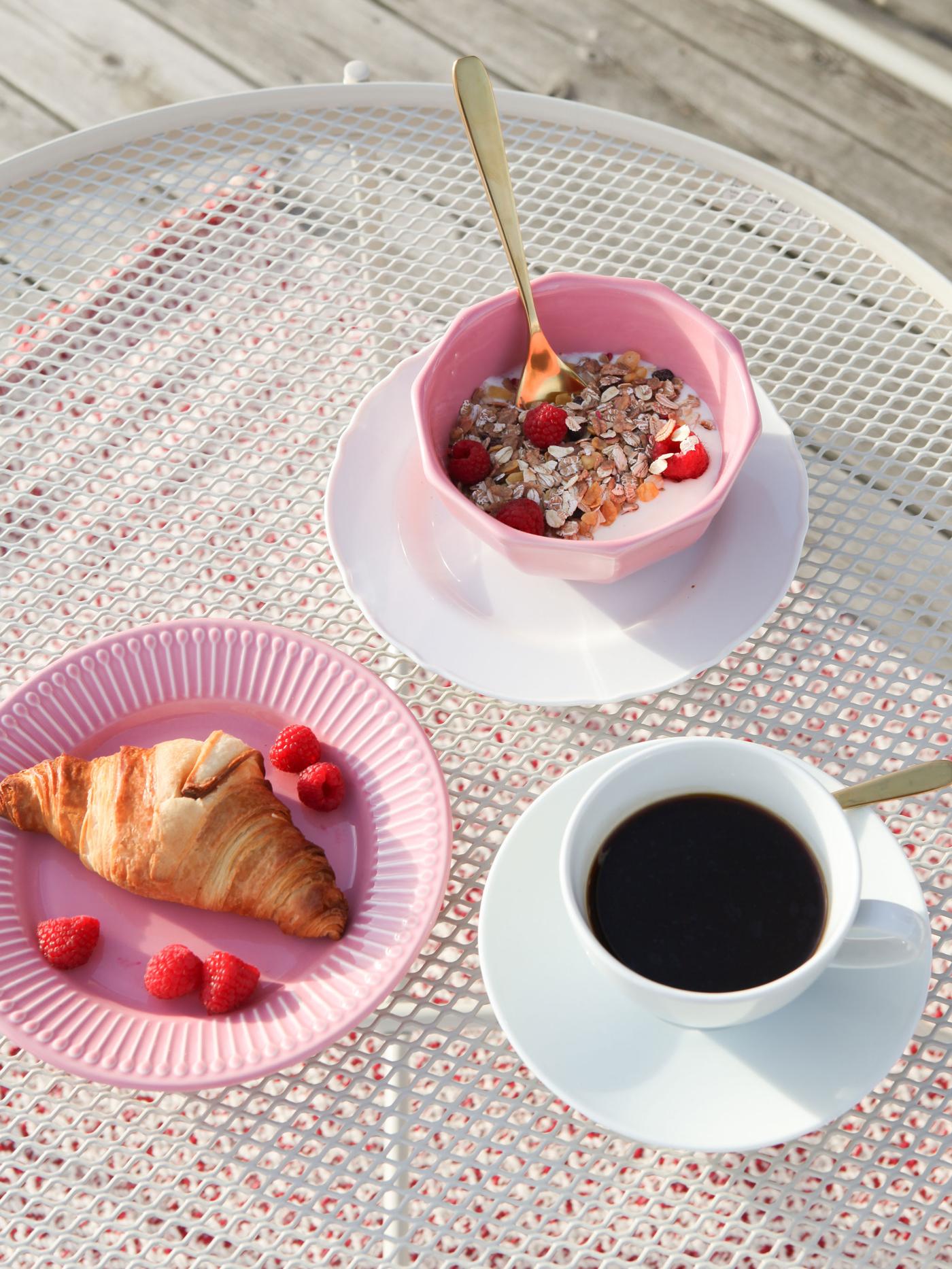 Rosa service med morgenmad på og en kop kaffe plceret på et KROKHOLMEN bord.
