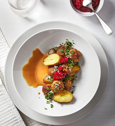 Rosted potatoes with HUVUDROLL plant balls, cream sauce and toped with greens