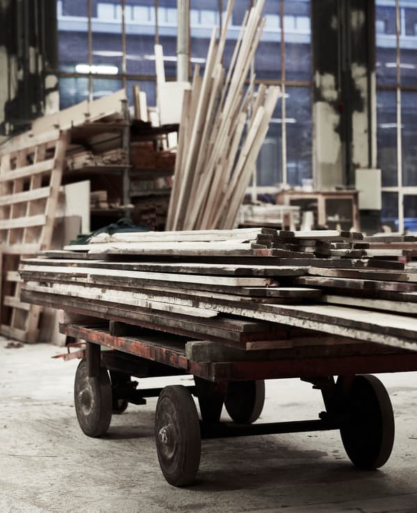 Rough cuts of wood stacked up in a workshop.