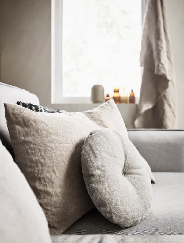 Round and rectangular pillows decorate a sofa.
