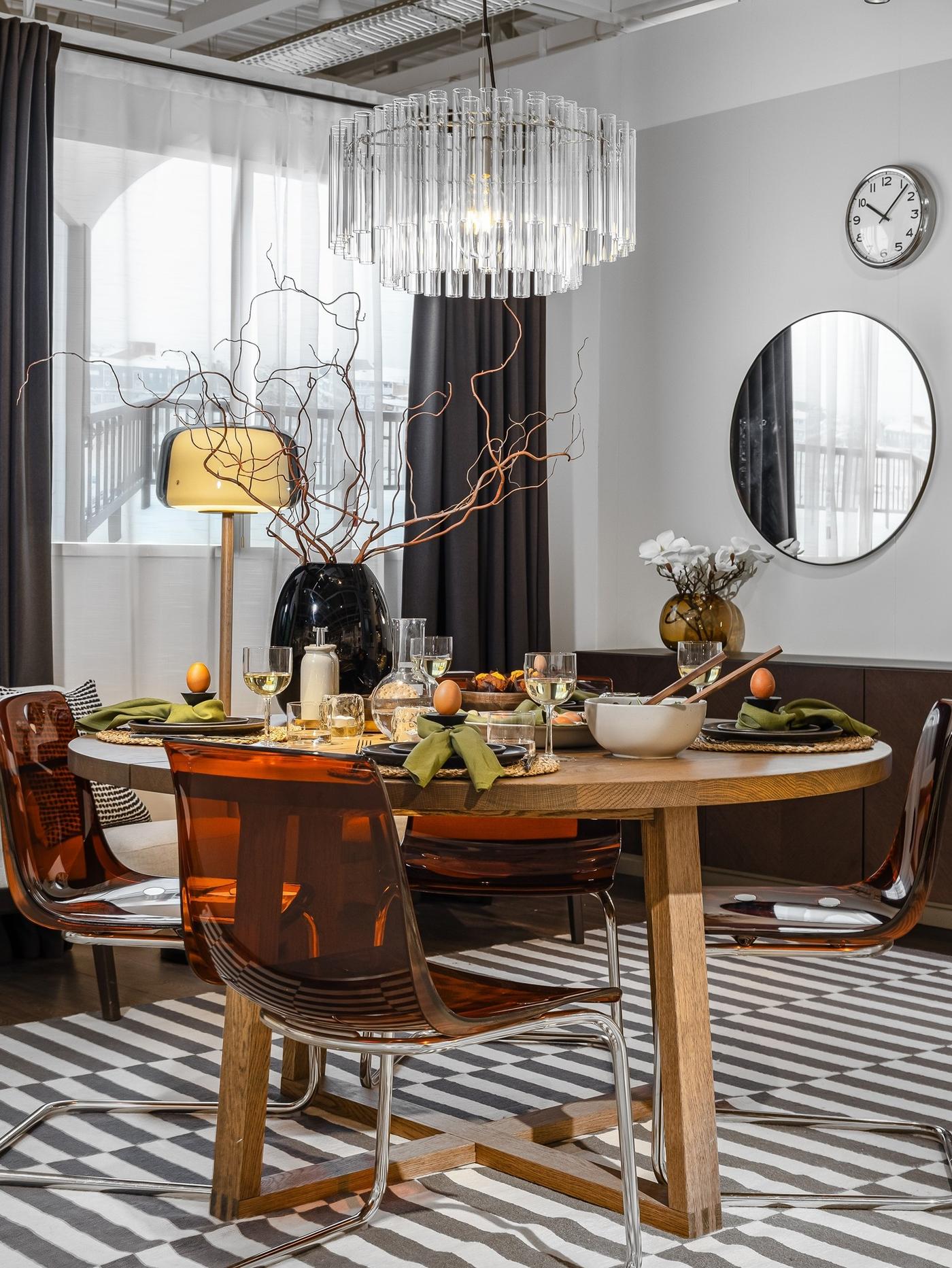 Round wooden dining table set for Easter, left uncovered and styled with earthy-toned tableware.