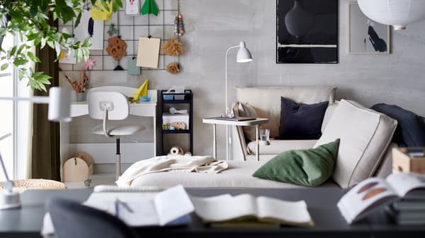 Ruang tamu dengan tempat kerja kecil di sudut, meja komputer riba berdekatan kerusi berlengan dengan kusyen dan chaise longue.
