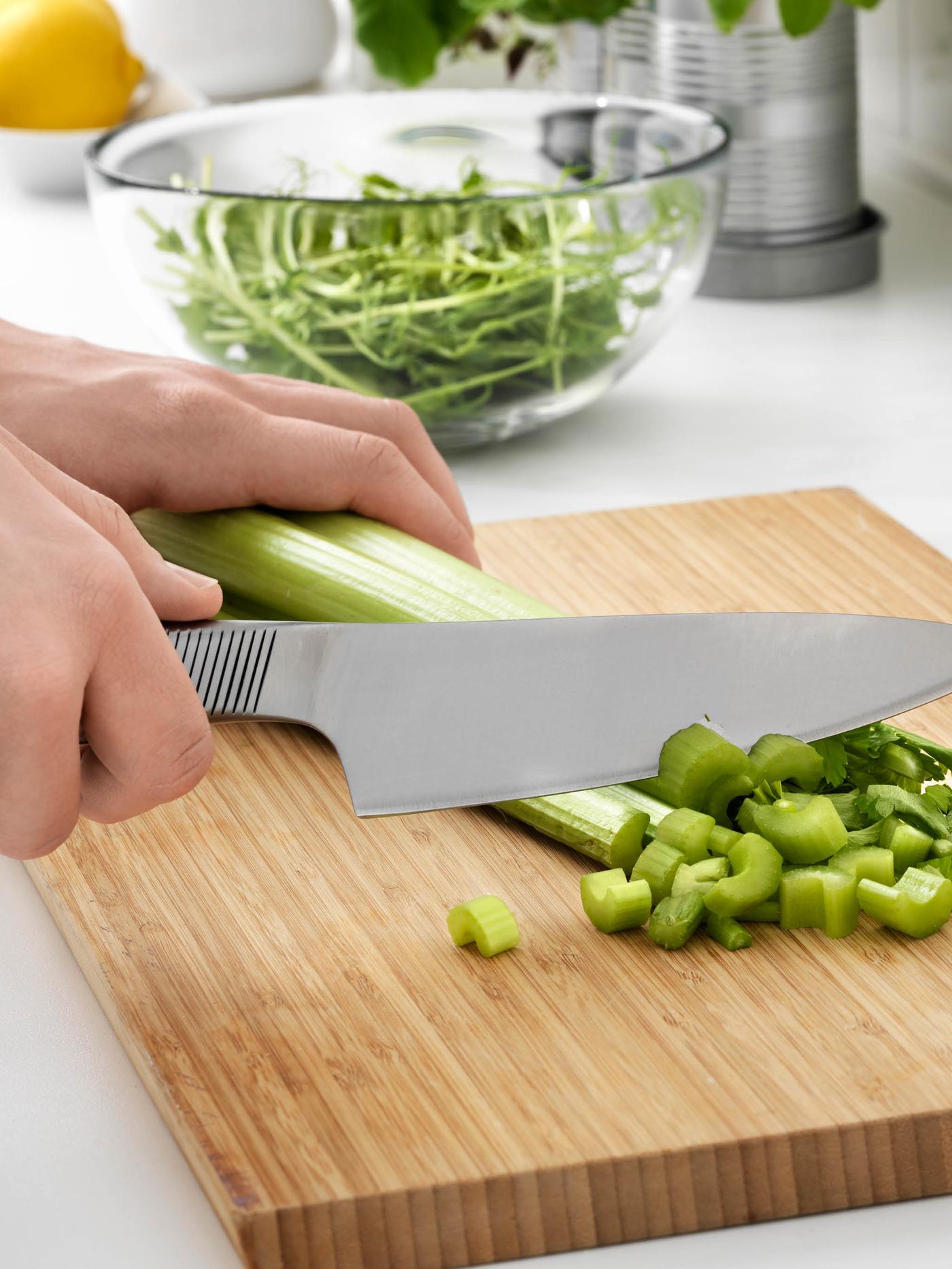 Ruce krájí nožem IKEA 365+ celerovou nať na prkénku APTITLIG.