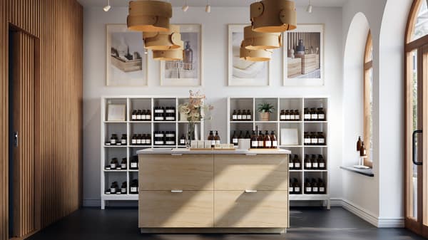 Ruim winkelinterieur met veel licht met centraal een groot keukeneiland met ASKERSUND ladefronten in licht essenpatroon.
