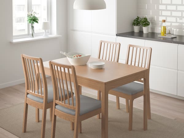 明るい木目のダイニングテーブルと椅子を置いたシンプルな食卓。窓辺で自然光が差し込むナチュラル空間。