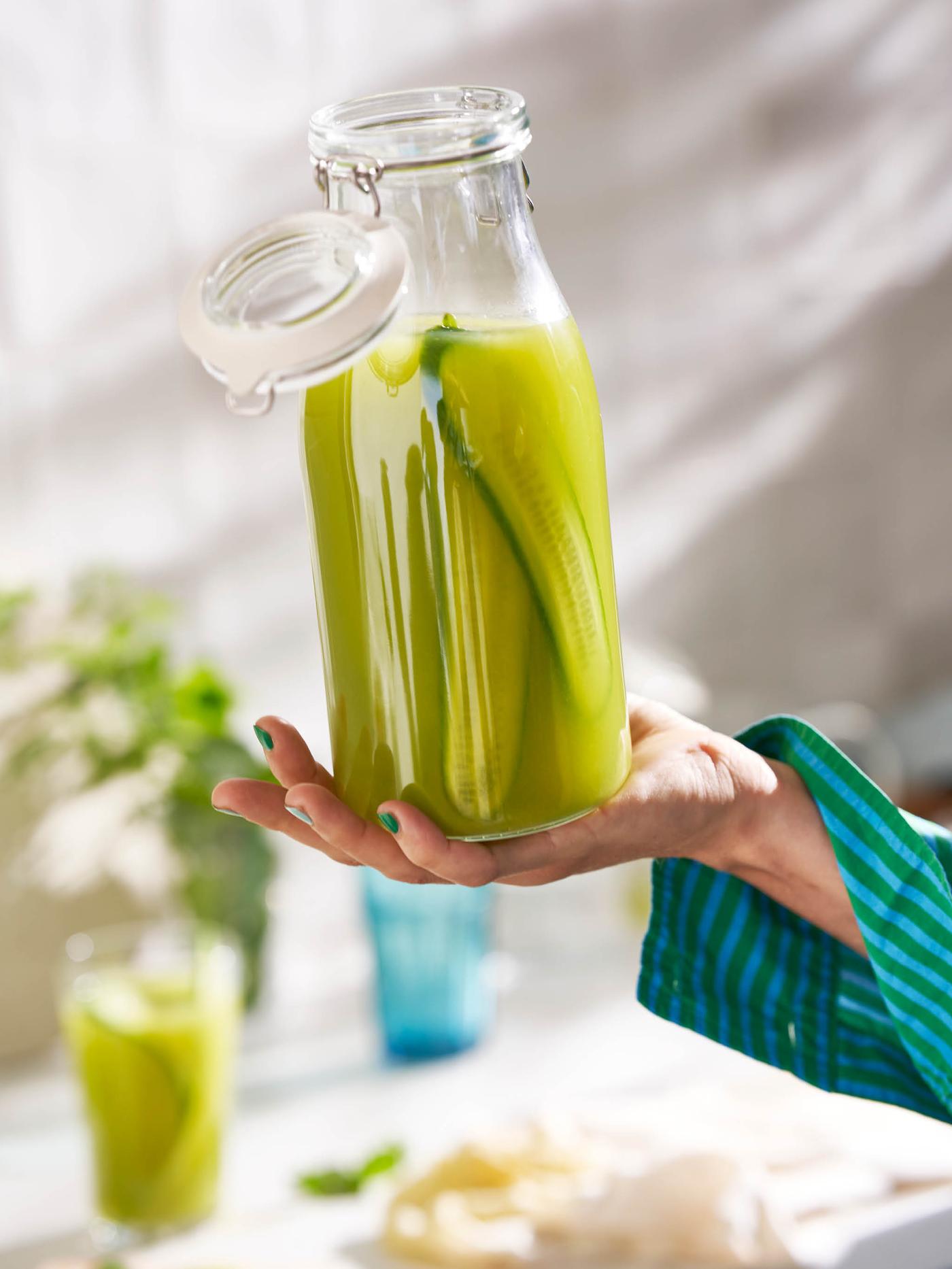 Ruka drží sklenici s víkem KORKEN se zeleným nápojem.