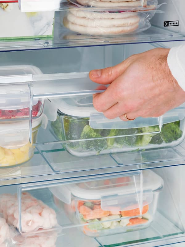 Ruka otvára zásuvku mrazničky.