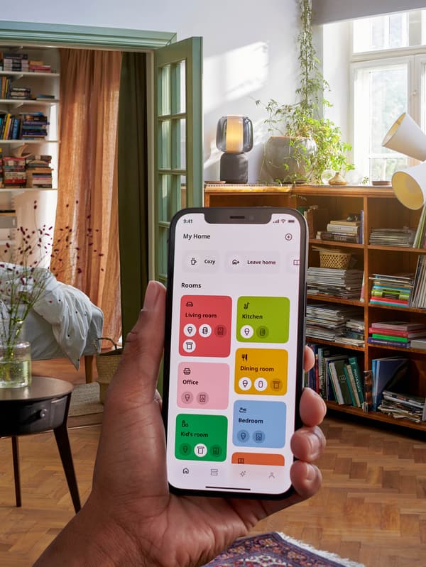 Ruka s mobilním telefonem s aplikací IKEA Home smart. 