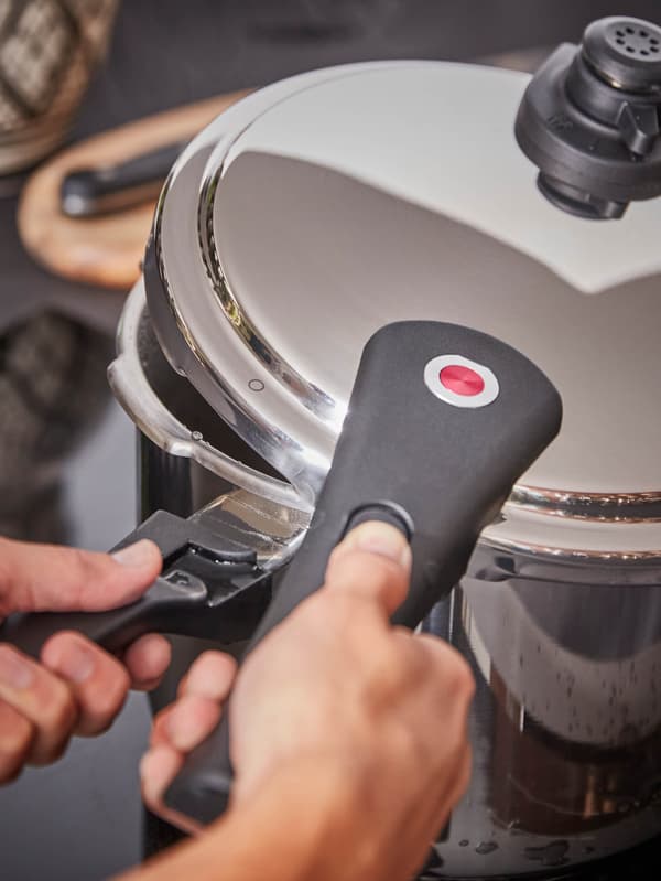 Ruky otvárajú tlakový hrniec IKEA 365+.