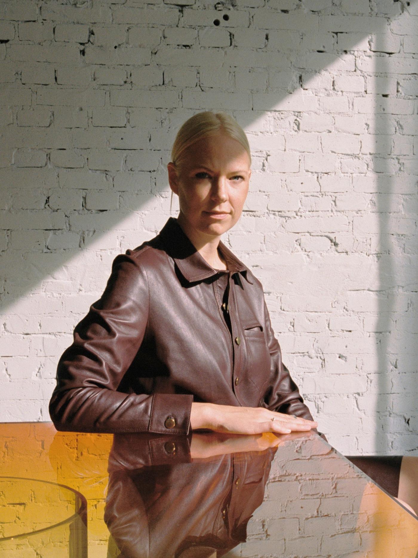 Sabine Marcelis diseinatzailea gainazal islatzailea daukan mahai baten ondoan eserita dago.