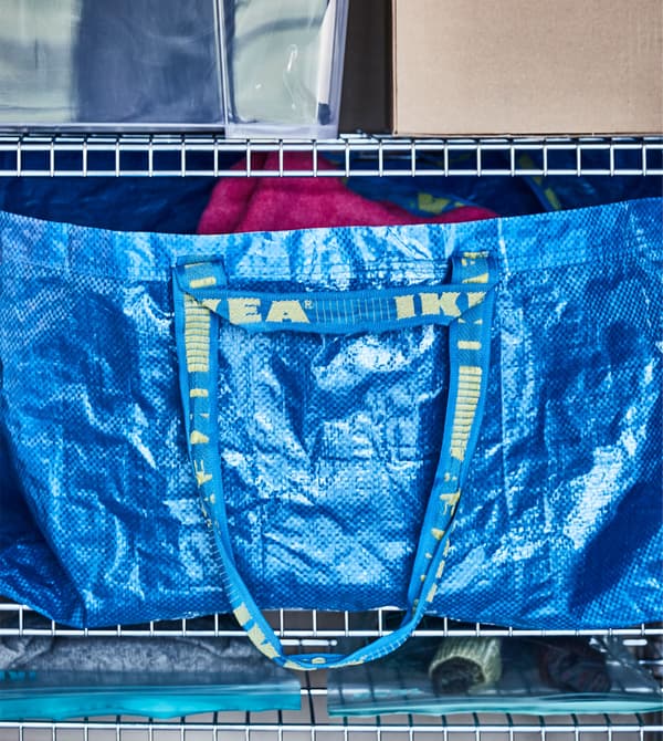 Sac bleu IKEA avec équipement de sport d’hiver, sur une étagère.