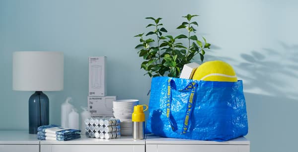 Saco FRAKTA e produtos IKEA em cima de um móvel