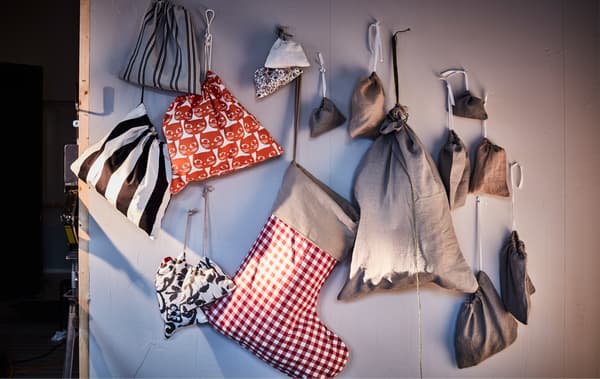 Sacs et pochettes à cadeaux de taille différentes accrochés au mur.