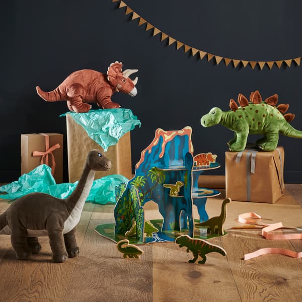 Sada plyšových dinosaurů rozmístěných po místnosti.