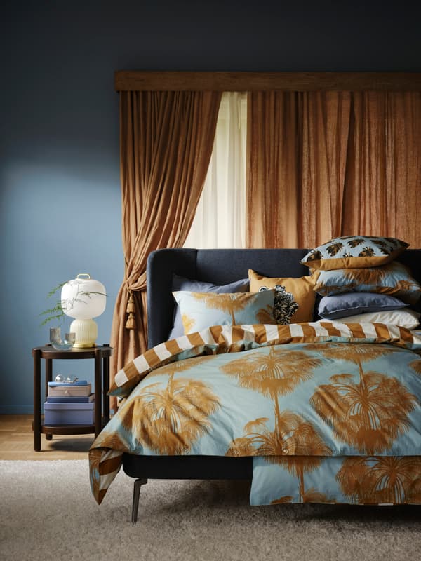 Säng med kuddar och färgglatt täcke