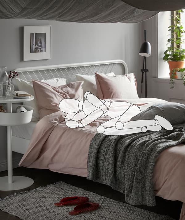 Sagoma di un manichino coricato in posizione fetale su un letto fatto e del tessuto appeso al soffitto per formare delle volte - IKEA