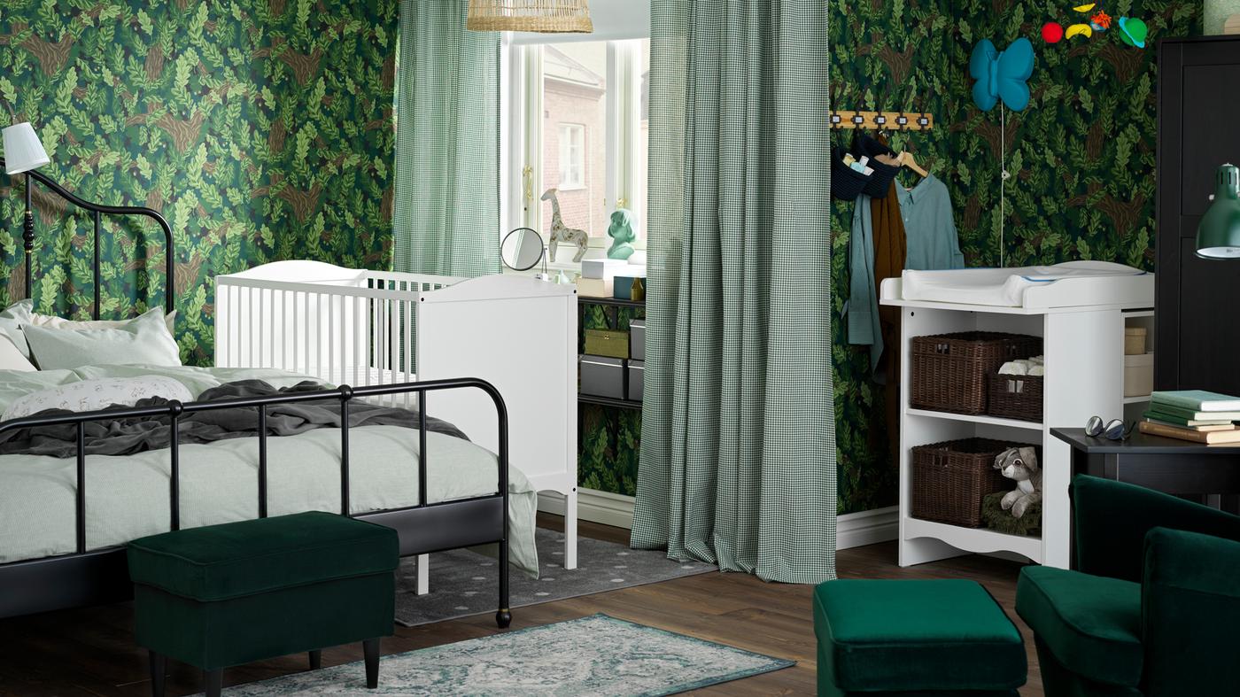 ห้องนอนของครอบครัวที่มีเตียงคู่ SAGSTUA/ซ้ากสตัว สีดำตั้งอยู่ข้างเตียงเด็กอ่อน SMÅGÖRA/สมัวเยอรา สีขาว ใกล้กันมีโต๊ะเปลี่ยนผ้าอ้อม SMÅGÖRA/สมัวเยอรา