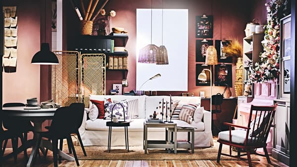 Sala de estar con sofá blanco, mesas de centro negras y una mesa de comedor negra redonda.