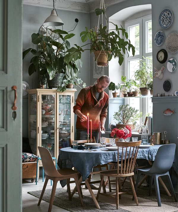 Salle à manger avec couverts, verres, chaises et coussins.