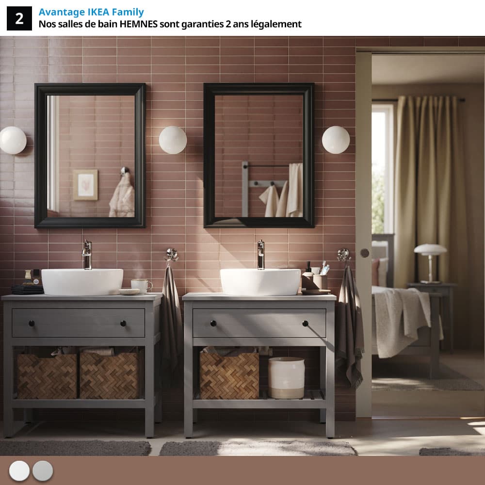 Salle de bain aux carrelages roses, avec meubles gris et miroirs rectangulaires noirs