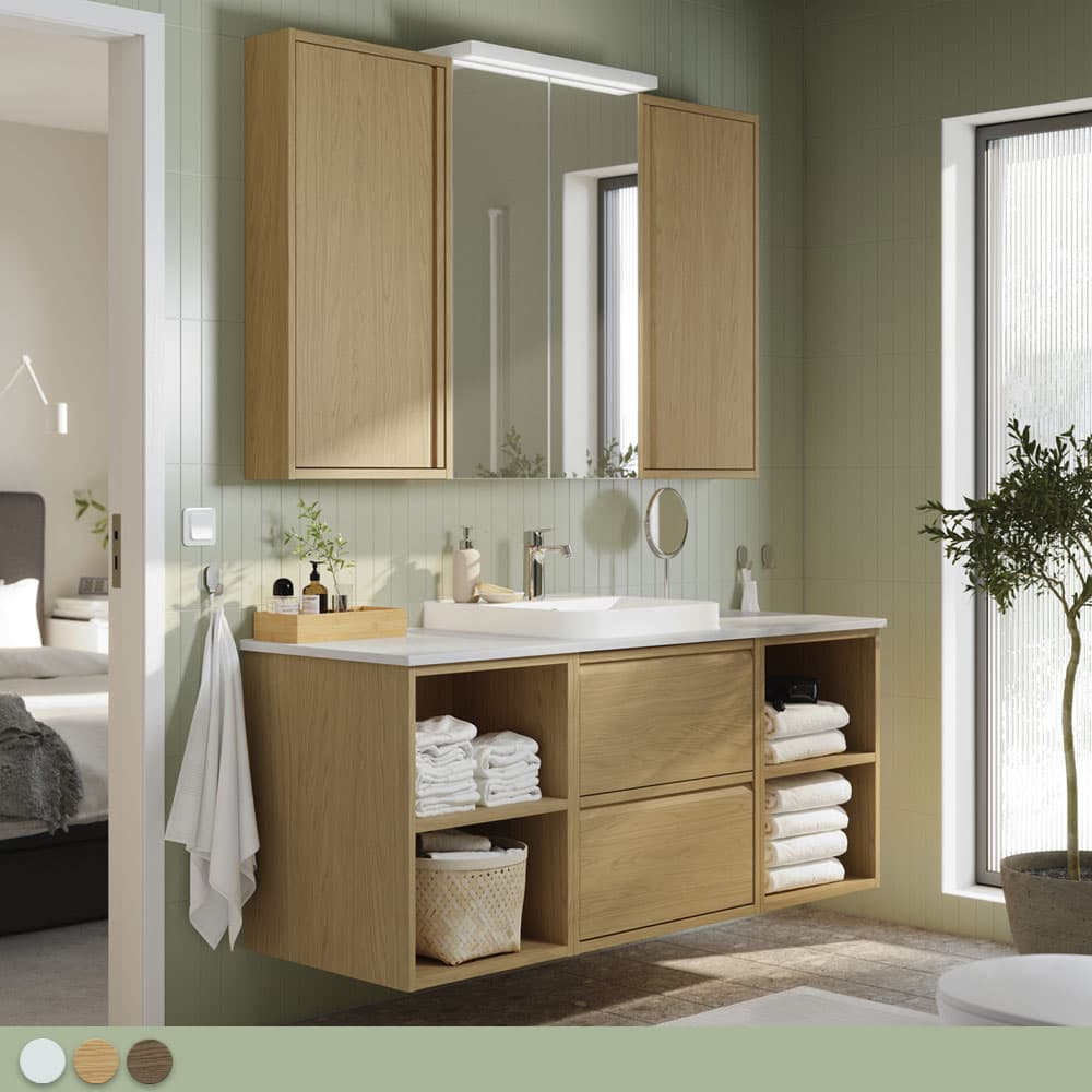 Salle de bain blanche et verte claire, avec un ensemble de meuble couleur bois clair.