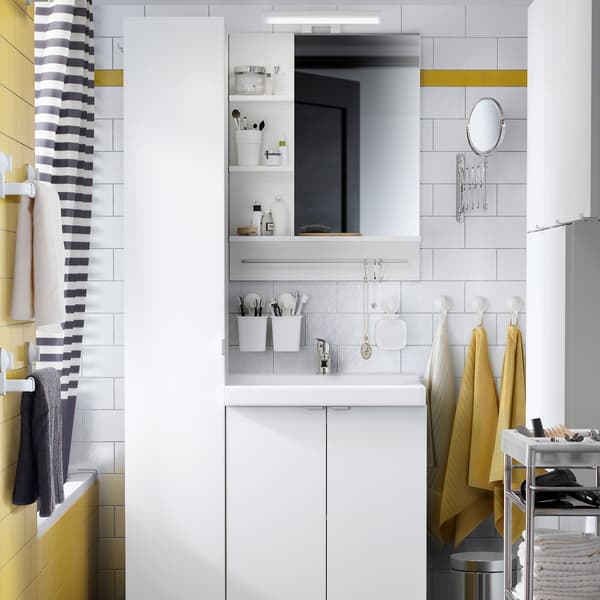 Salle de bain noire, blanche et jaune avec élément lavabo 2 portes blanc LILLÅNGEN/TALLEVIK, élément mural LILLÅNGEN et armoire LILLÅNGEN blancs, offrant beaucoup de rangements et donnant à la pièce un look and feel organisé.