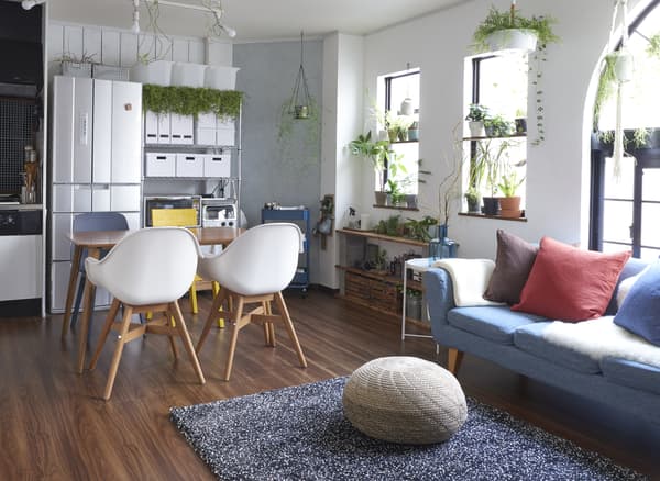 Salon avec canapé, tapis, table à manger et chaises, et des boîtes de rangement contre le mur.