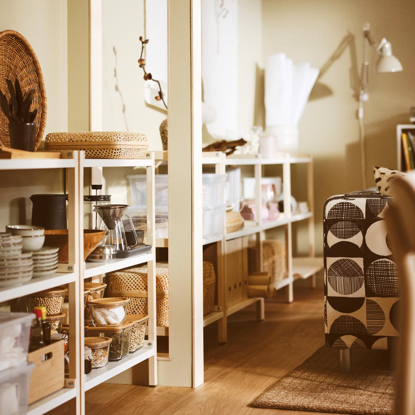 Salon avec des étagères EKENABBEN contenant des bols GLADELIG, une cafetière HÖGMODIG et des boîtes avec couvercle.