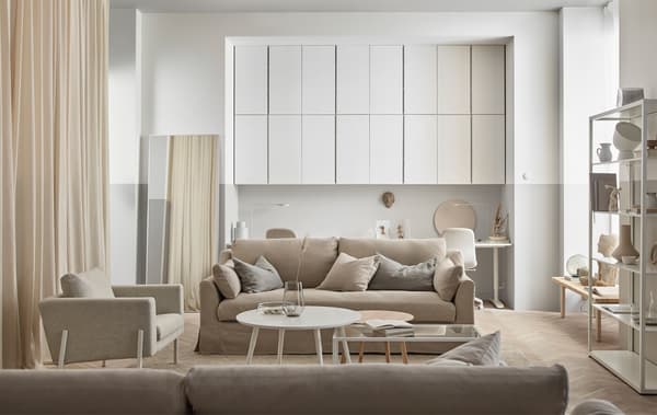 Salón beige y blanco con una pared de armarios IVAR pintados en tonos parecidos a los de la estancia.