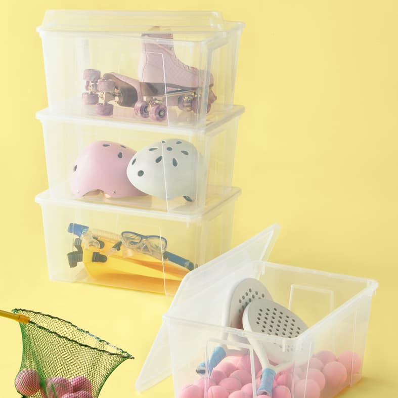 SAMLA storage boxes stacked on top of each other with sports equipments and toys. 