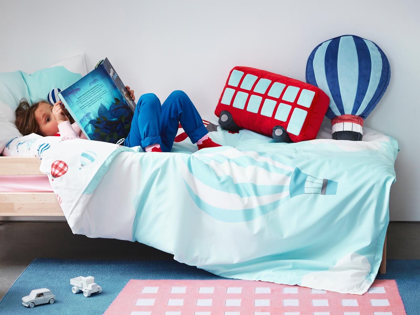 Sarung kuilt, ambal dan kusyen daripada koleksi tekstil kanak-kanak UPPTÅG dengan grafik berwarna-warni berdasarkan tema pengembaraan.