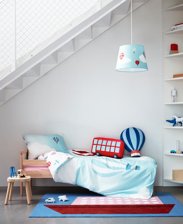 Sarung kuilt, ambal, lampu dan kusyen daripada koleksi tekstil kanak-kanak UPPTÅG dengan grafik berwarna-warni tentang pengembaraan.