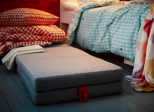 Save space by turning play material into bed material. IKEA SLÄKT children’s mattresses make comfy guest beds for friends. Layer two on top of on another for an extra cozy night.
