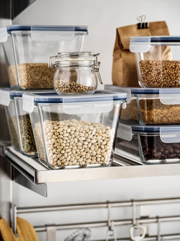 Scaffale da cucina con contenitori per alimenti IKEA 365+ in vetro trasparente, impilati e pieni di legumi secchi.