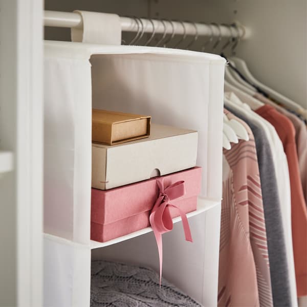 Scatole in un portatutto a 6 scomparti vicino ai vestiti appesi su un bastone appendiabiti - IKEA