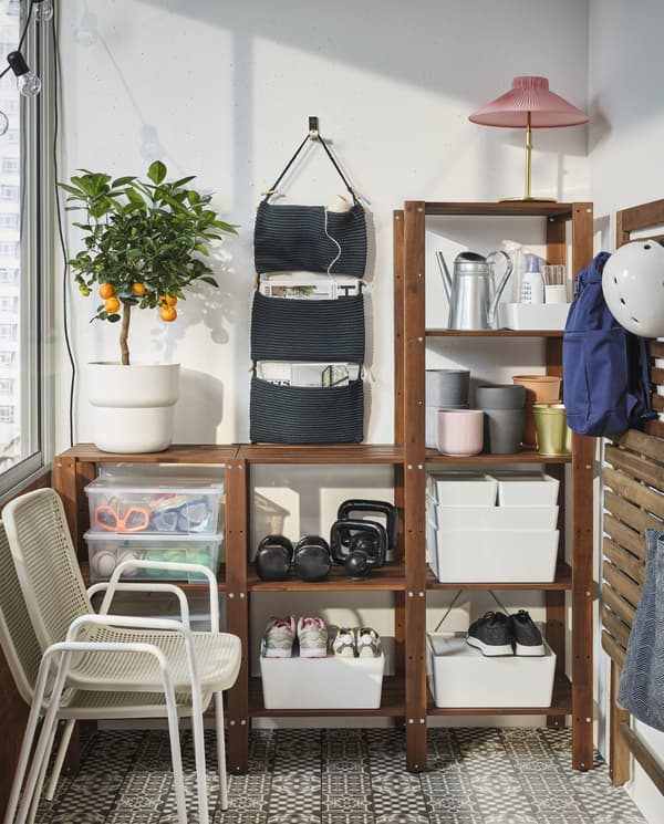 Scatole, portavasi, scarpe e altri accessori sono organizzati in uno spazioso scaffale in legno, con davanti due sedie impilate - IKEA