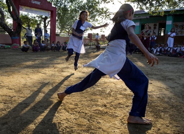 Scène d'une soirée en plein air dans un pays d'Orient où des filles courent dans la cour d'école.