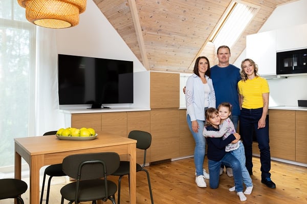 Счастливая семья вместе в современной кухне с деревянным потолком и обеденной зоной