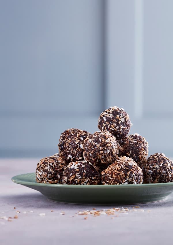 Schwedische Schokokugeln von IKEA auf grünem Teller, verziert mit Kokosraspeln – süße Delikatesse im IKEA Bistro